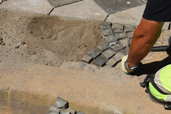 Worker lays paving stones