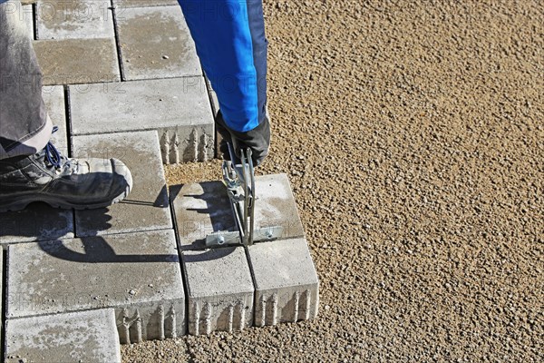 Workers lay paving stones