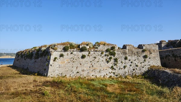 Part of the ruins of a stone fortress with grassy areas in front, sea fortress Methoni, Peloponnese, Greece, Europe
