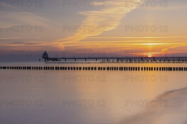 Sunrise at the pier of zingst with groynes in the foreground