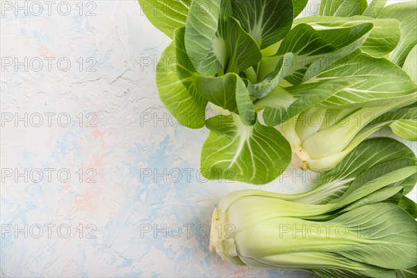 Fresh green bok choy or pac choi chinese cabbage on a white concrete background. Top view, copy space, flat lay