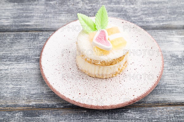 Decorated cake with milk and coconut cream on a gray wooden background. Side view, close up