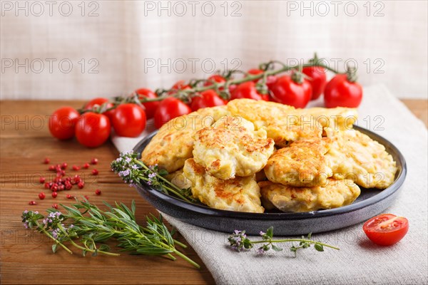 Minced chicken cutlets with herbs on brown wooden background. side view, close up, selective focus