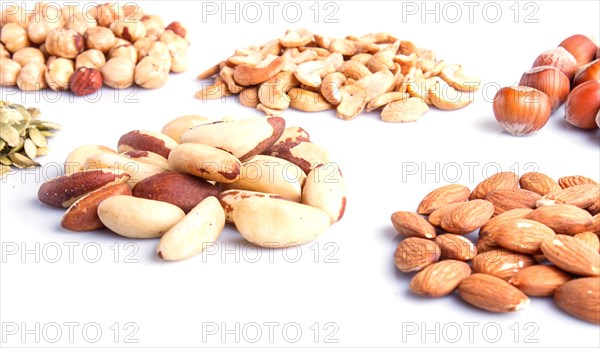 Piles of various nuts and seeds isolated on white background. hazelnut, brazil nut, almond, pumpkin seeds, cashew. close up