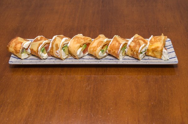 A plate of sushi rolls topped with cream sauce and slices of green lettuce, Majorca, Balearic Islands, Spain, Europe