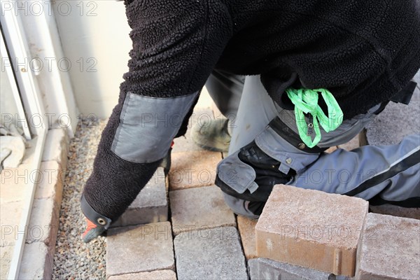 Worker lays paving stones