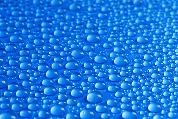 Many small water drops on a blue surface