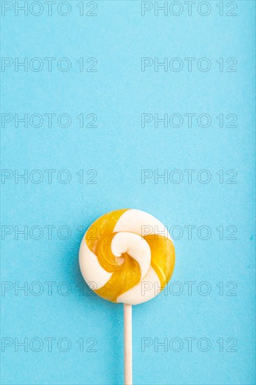 Single lollipop candy on blue pastel background. copy space, top view, flat lay