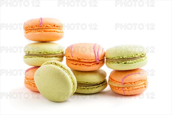 Orange and green macarons or macaroons cakes isolated on white background. side view, close up, macro