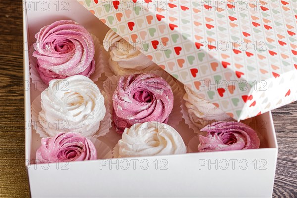 White box with pink and white homemade zephyr on gray wooden background