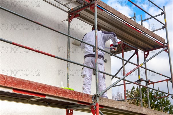 Painter painting the facade of a new residential building