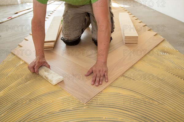 Craftsmen laying herringbone parquet professionally