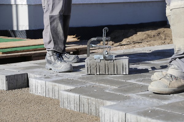 Workers lay paving stones