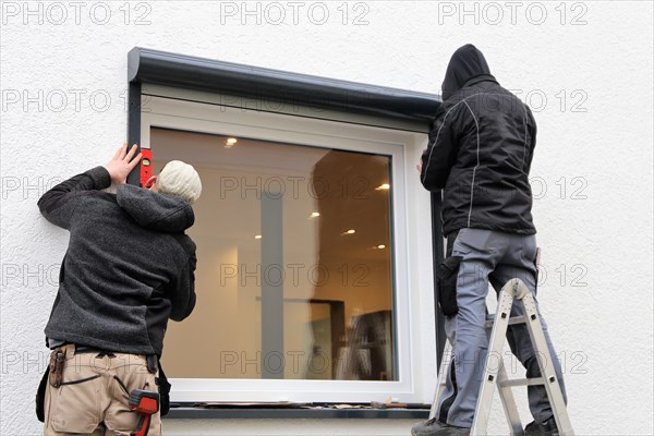 Craftsmen install a front-mounted roller shutter