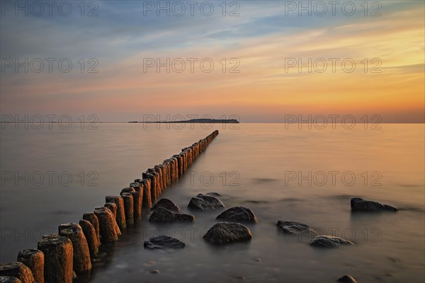 Sunset in Dranske on Ruegen with a view over the groynes to Hiddensee