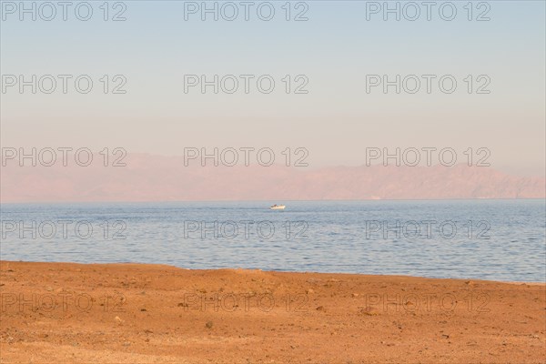 The coastline of the Red Sea and the mountains in the background, sunset. Egypt, the Sinai Peninsula, Dahab