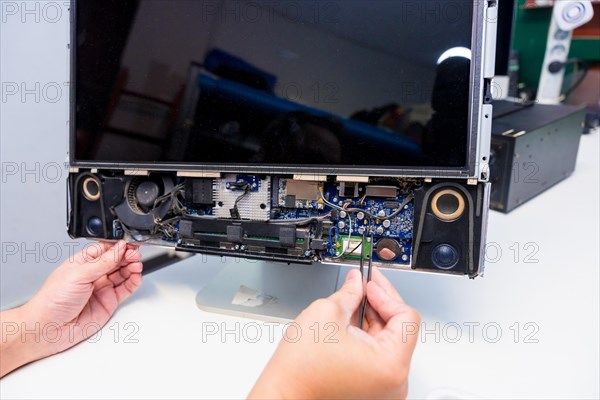 Close-up of the hands of a IT Engineer repairing a computer in a workshop