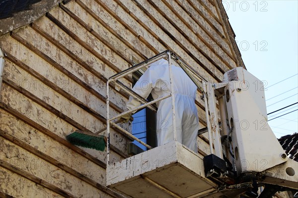 Professional asbestos removal by workers in protective suits