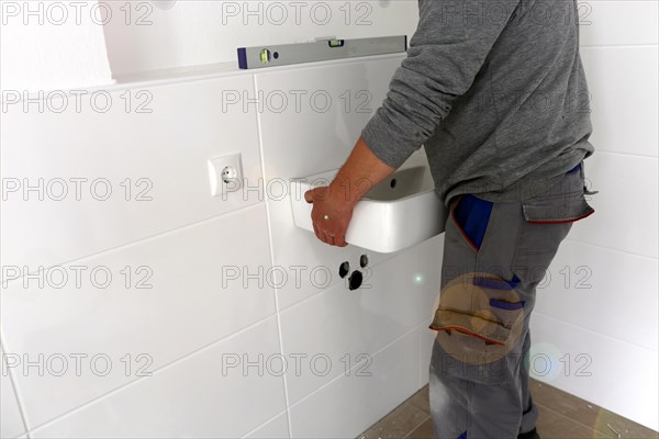 Plumber installs a new washbasin