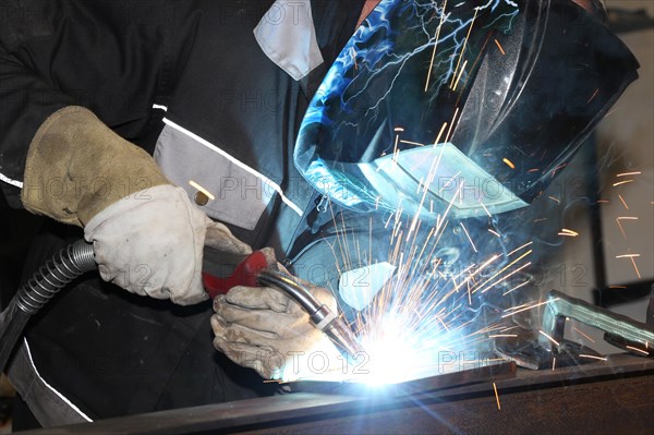 Metalworker during welding work in his workshop