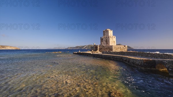 An old castle at sunset overlooking the calm sea, octagonal medieval tower. Bourtzi islet, Methoni sea fortress, Peloponnese, Greece, Europe