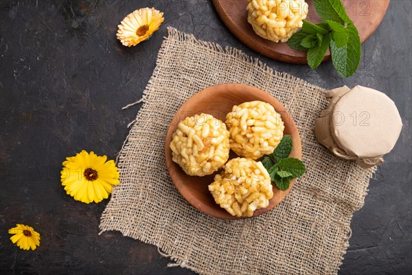 Traditional Tatar candy chak-chak made of dough and honey with cup of coffee on a black concrete background and linen textile. top view, flat lay, close up