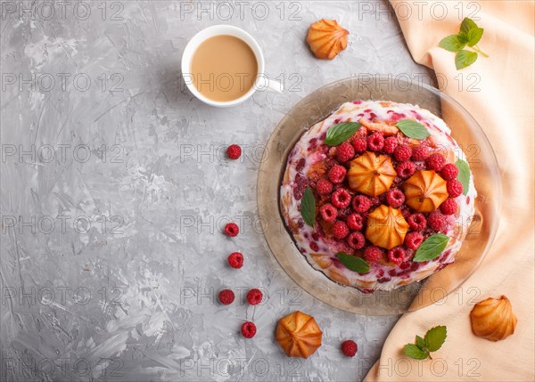 Homemade jelly cake with milk, cookies and raspberry on a gray concrete background with cup of coffee and orange textile. top view. flat lay, copy space