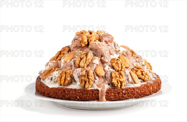 Homemade cake with milk cream, cocoa, almond, hazelnut isolated on white background. Side view, close up