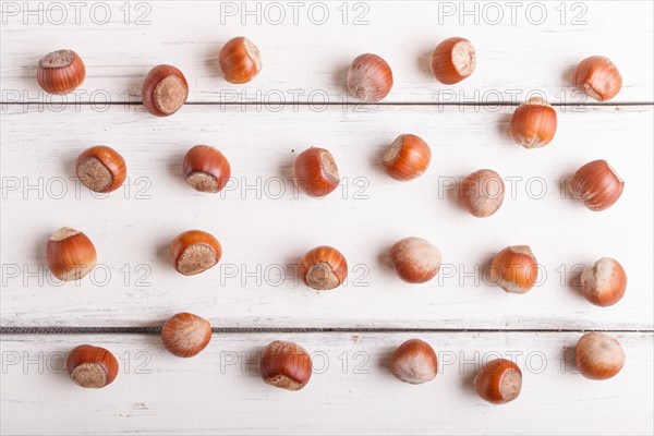 Pattern and texture made from hazelnuts on white wooden background, flat lay. top view
