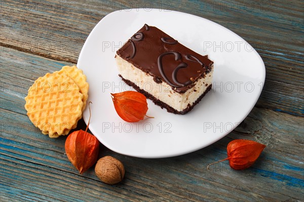 Sweet waffle, cake with cream and red physalis on a rustic blue wooden background