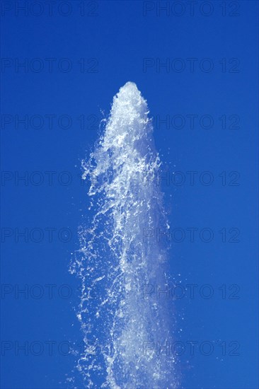 Water from a fountain in the blue sky