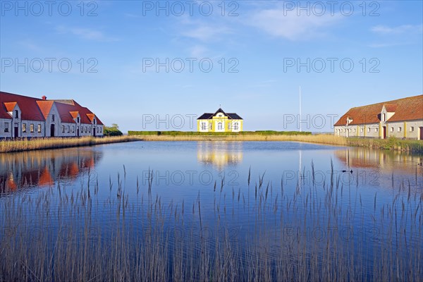 Large houses and the teahouse at Valdemars Slot are reflected in the calm water, Valdemars Slot, Manor Route, Tasinge, Denmark, Europe