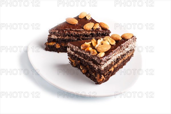 Chocolate cake with caramel, peanuts and almonds isolated on a white background. close up