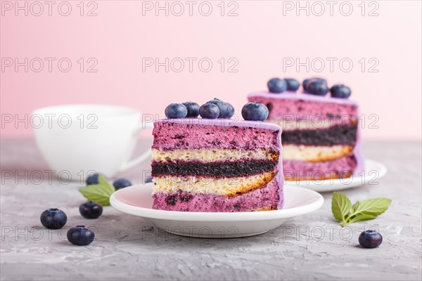 Homemade cake with souffle cream and blueberry jam with cup of coffee and fresh blueberries on gray and pink background. side view, selective focus, close up