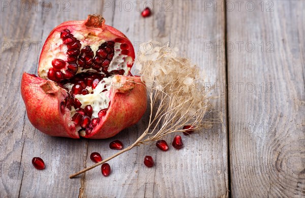 Opened ripe garnet with seeds on a rustic wooden background