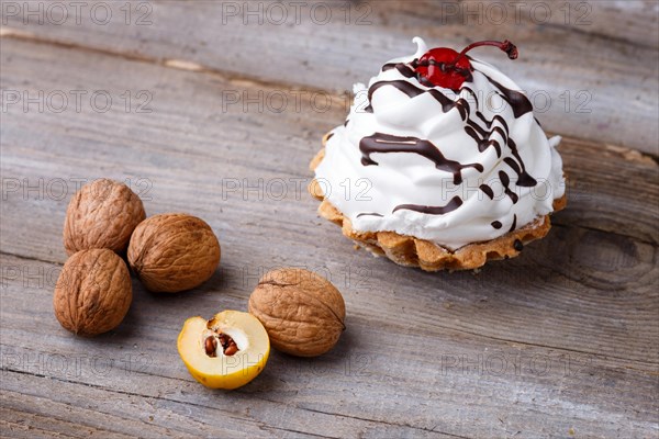 A cake with cream and walnuts on a rustic wooden background with copy space