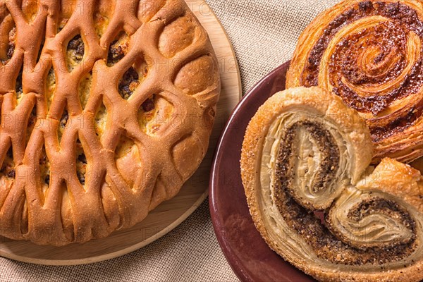 Sweet buns on a wooden board and linen tablecloth