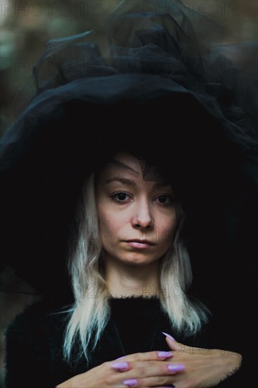 Portrait of a woman in a large tulle hat creating a dramatic and mysterious atmosphere