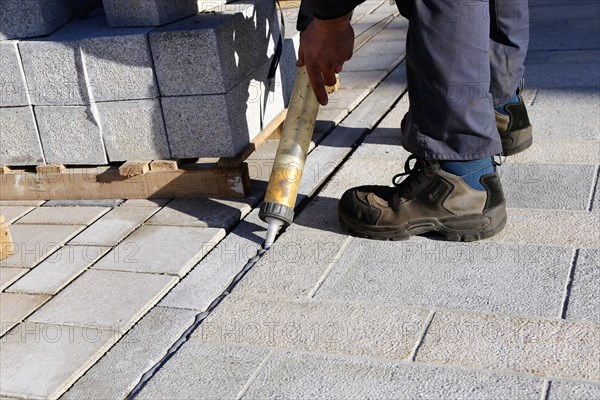 Worker lays paving stones