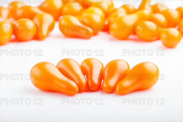 Five small ripe orange grape tomatoes and bunch of tomatoes on the back, isolated on white background. side view, close up