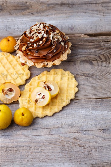 Sweet waffle and cake with cream on a rustic wooden background