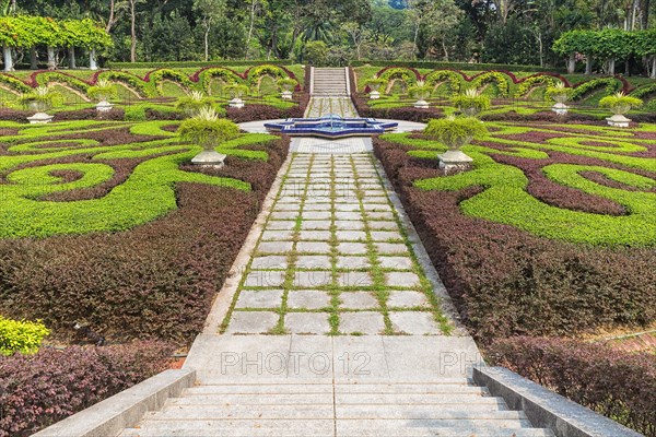 Part of a regular garden with cropped hedges and fountain