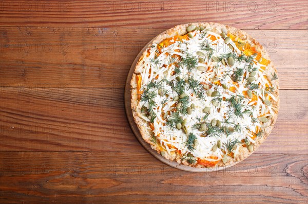 Sweet pumpkin pie with cheese and dill on brown wooden background. top view. copy space