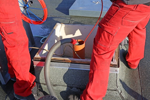 Workers from Abfluss AS clean the exhaust air ducts in an apartment block in Mannheim