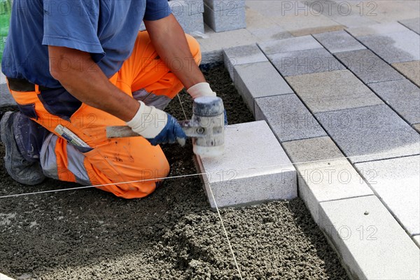 Worker lays paving stones