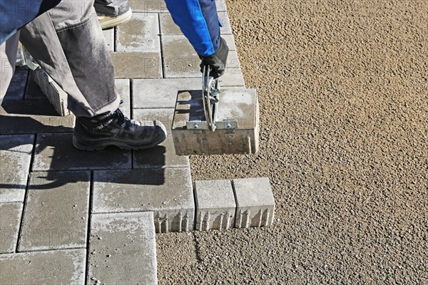 Workers lay paving stones