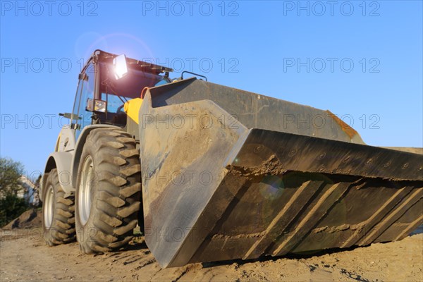 Wheel loader at sunset, here in the Ringstrasse development area (Mutterstadt, Rhineland-Palatinate)