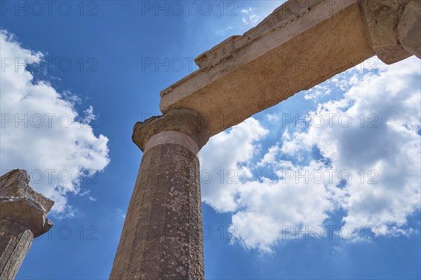 View upwards along ancient columns into the blue sky with white clouds, Archaeological site, Ancient Messene, capital of Messinia, Messini, Peloponnese, Greece, Europe