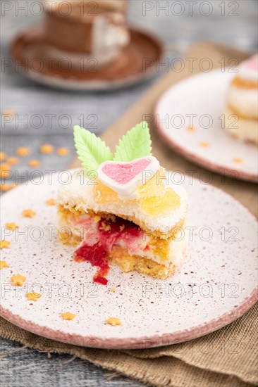 Decorated cake with milk and coconut cream with cup of coffee on a gray wooden background and linen textile. Side view, close up, selective focus