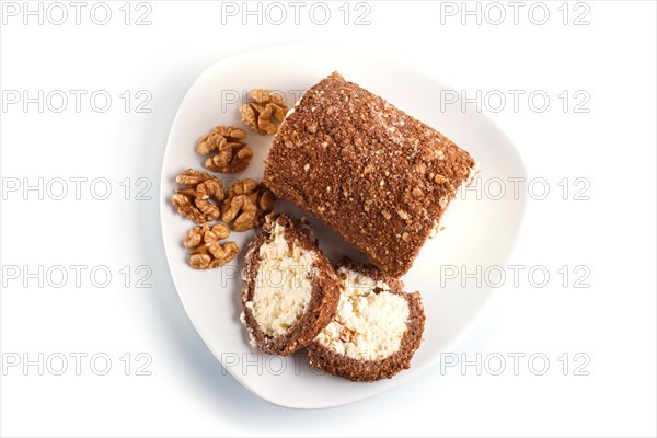 Roll cake with curd and walnuts isolated on white background. top view, close up